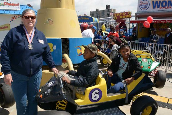 Community Mayor volunteer and children on amusement park ride