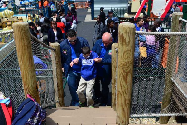 Two Community Mayors volunteers assisting child up steps