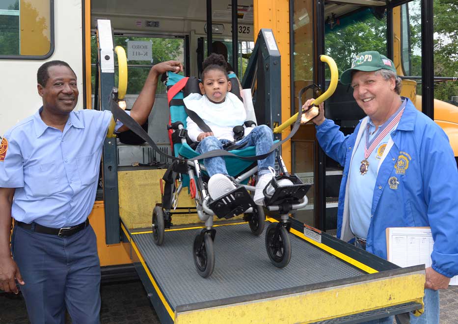 Two Community Mayors volunteers assisting little girl off school bus