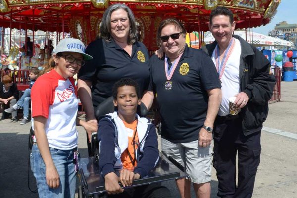 Community Mayors volunteers, chaperone and child at amusement park