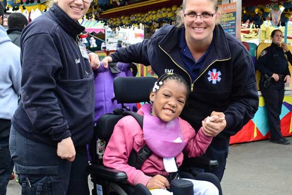 Community Mayors volunteers with child at amusement park