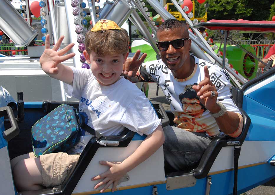 Father and son enjoying an amusement park ride at a Community Mayors Special Event
