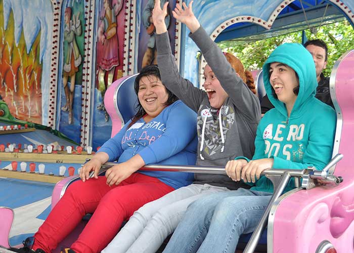 Group of teens enjoying amusement park ride