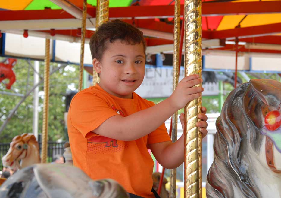 Little boy riding carousel