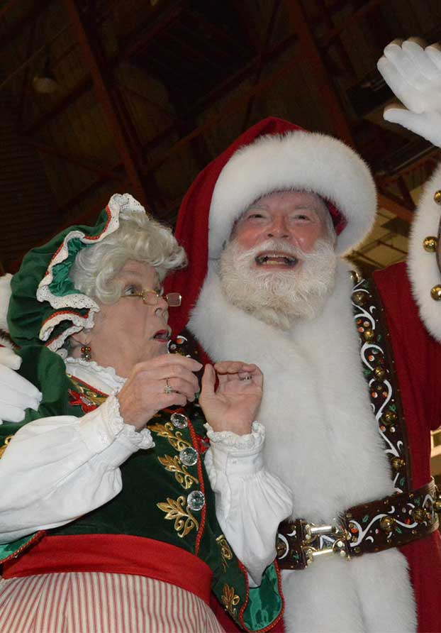 Macy's Santa Claus and Mrs. Claus waving to the crowd at Operation Santa Claus