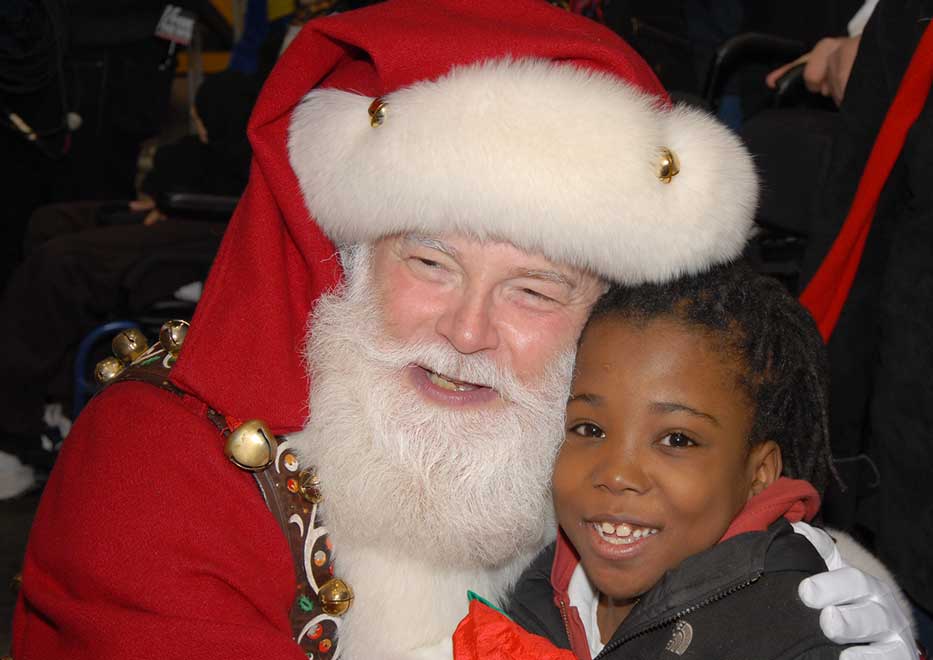 Santa Claus and child smiling at Operation Santa Claus event