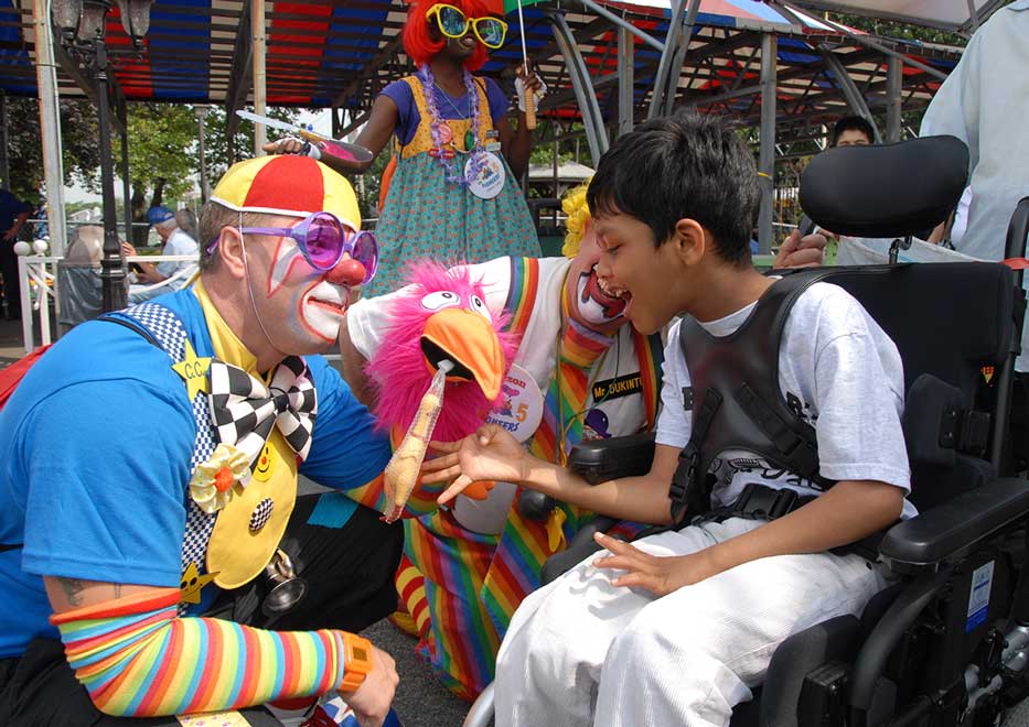 Special needs child interacting with a Community Mayors volunteer clown at an event