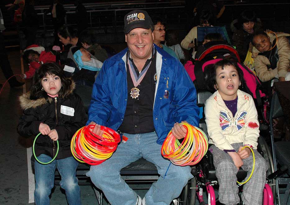 Two children with glow sticks and Community Mayor volunteer