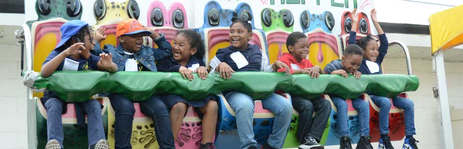 Group of children enjoying amusement park ride at Community Mayors special event