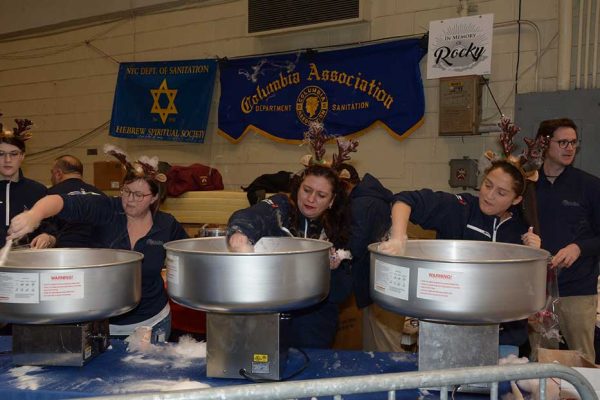 Volunteers at Operation Santa Claus event making cotton candy